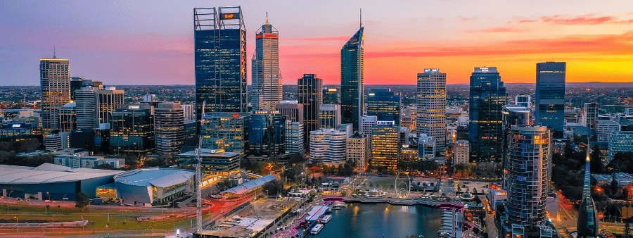 Panorama d'une ville australienne au coucher du soleil présentant des immeubles de bureaux et des gratte-ciel commerciaux pour l'immatriculation d'une entreprise en Australie