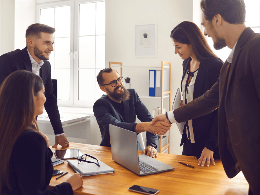 Business professionals shaking hands during a meeting to discuss an international expansion partnership