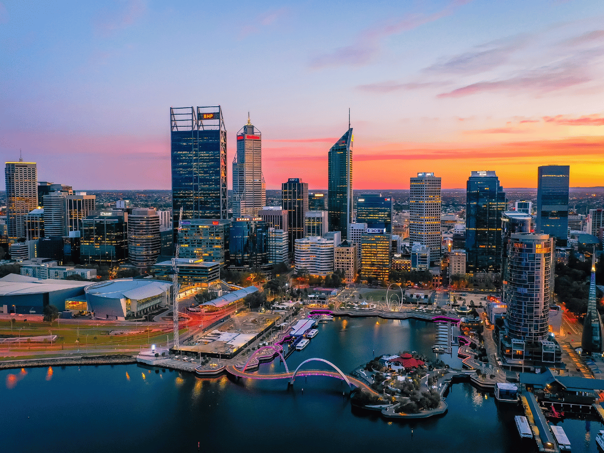Australian city skyline at sunset featuring corporate office buildings and commercial skyscrapers for registering a business in Australia.