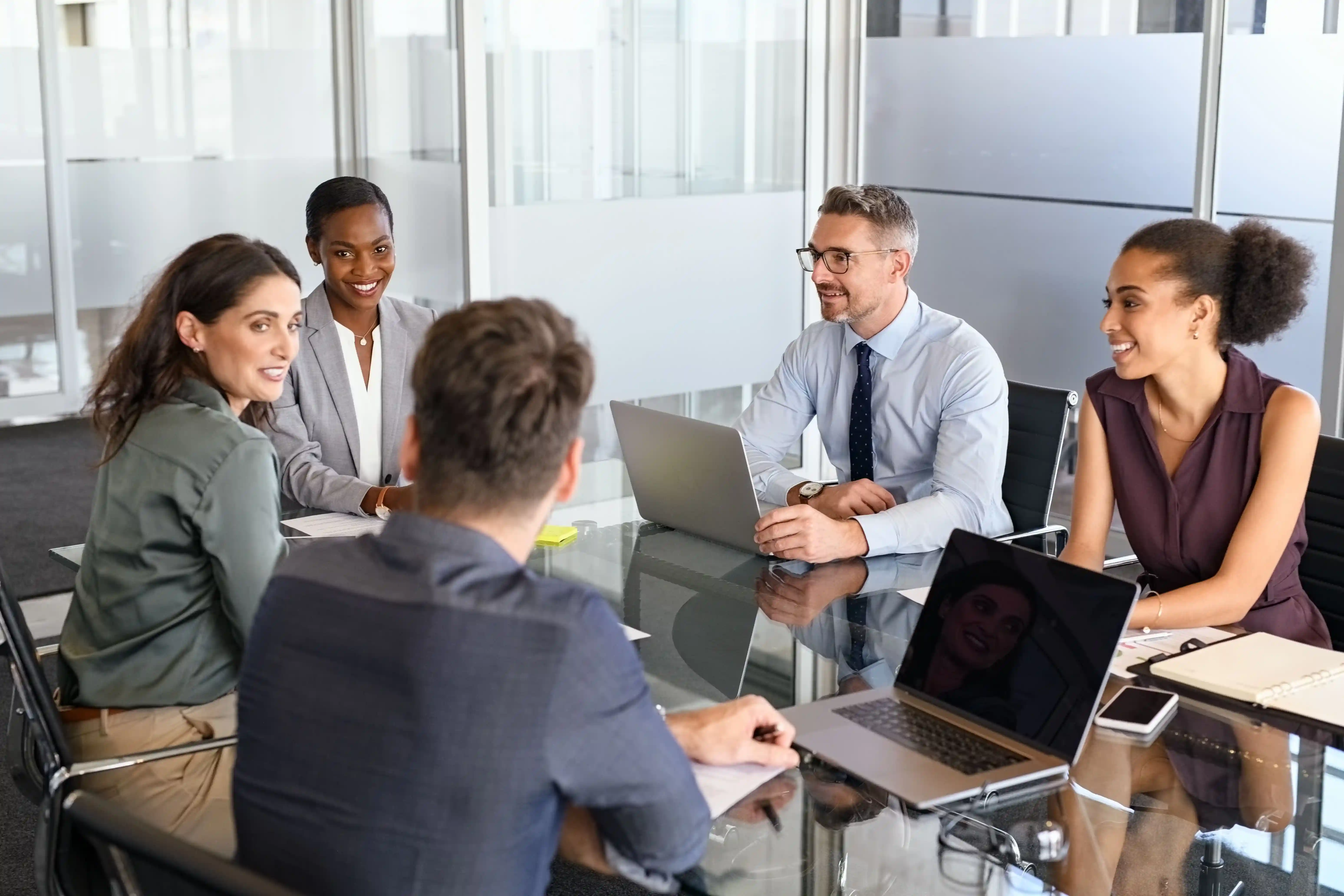 Diverses Unternehmens-Team bei Besprechung an einem Konferenztisch.